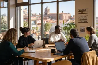 Entrepreneurs collaborating in a sunlit coworking space in southern France, with casual discussion and warm Occitanie atmosphere.